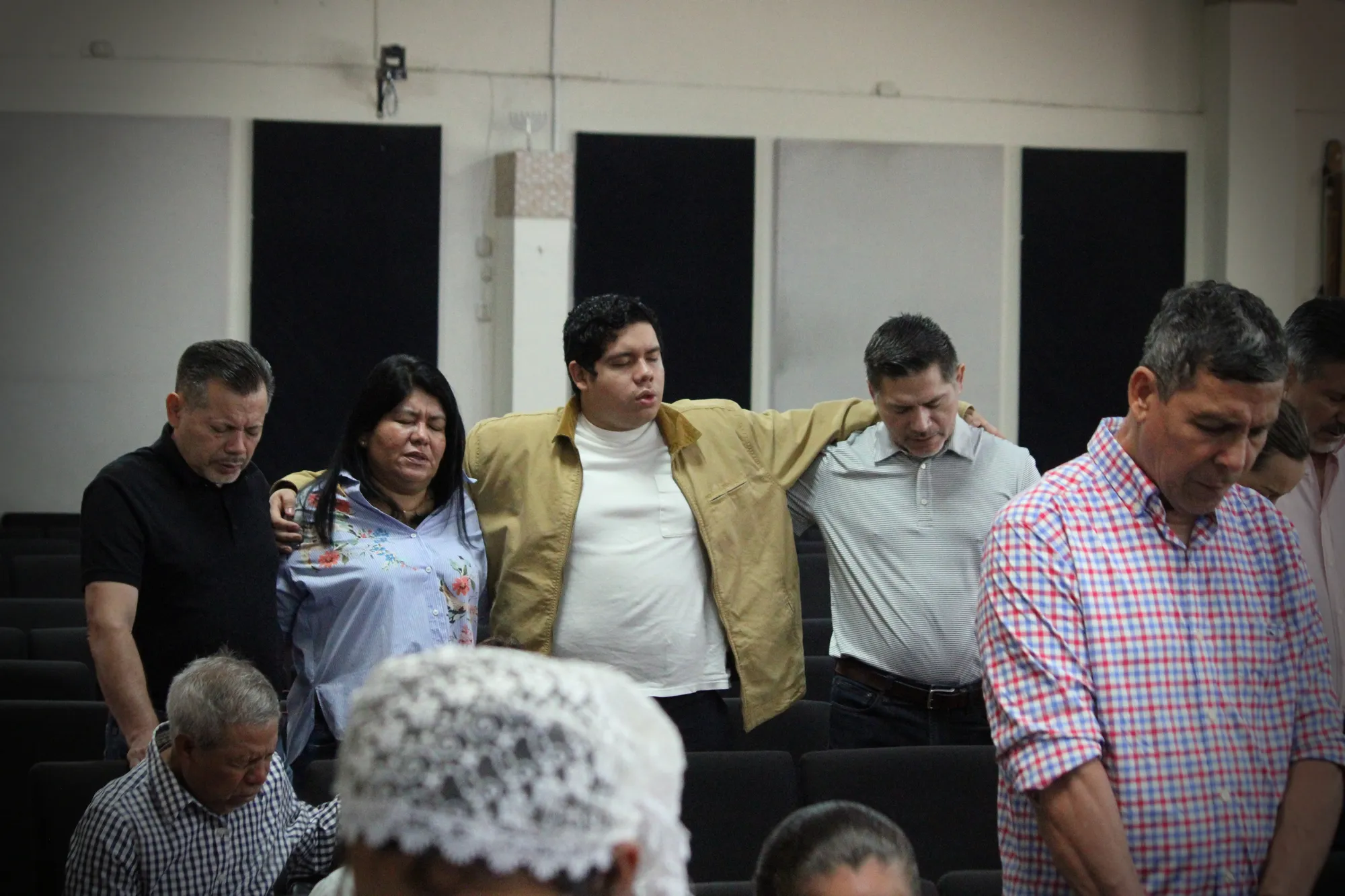 Miembros de Rey de Reyes orando juntos en comunidad